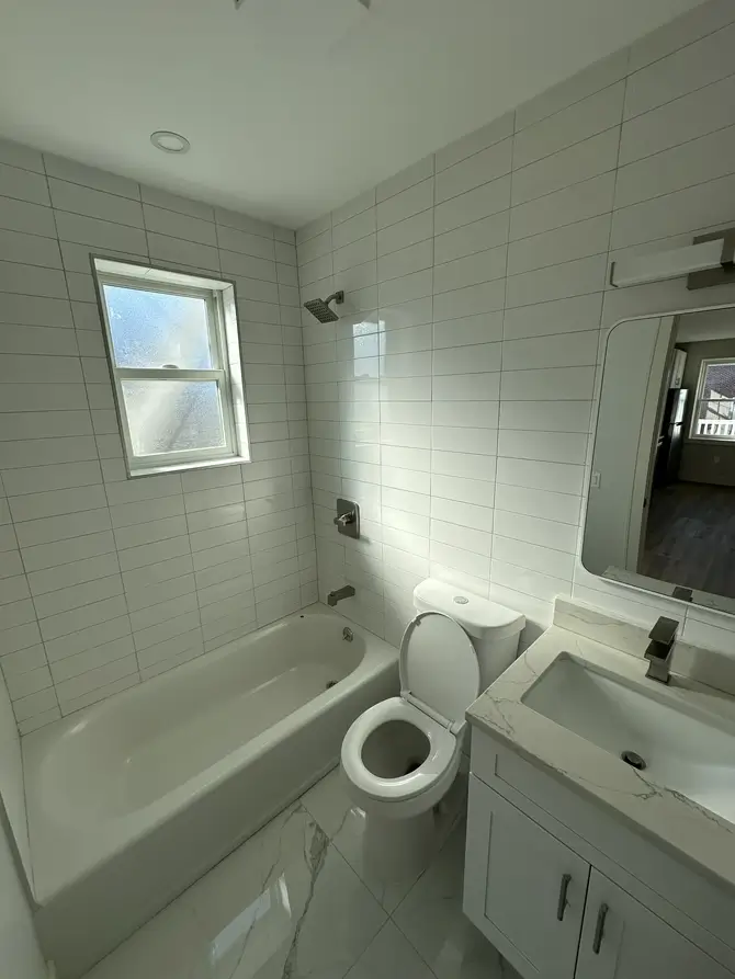Renovated bathroom with bathtub and vanity