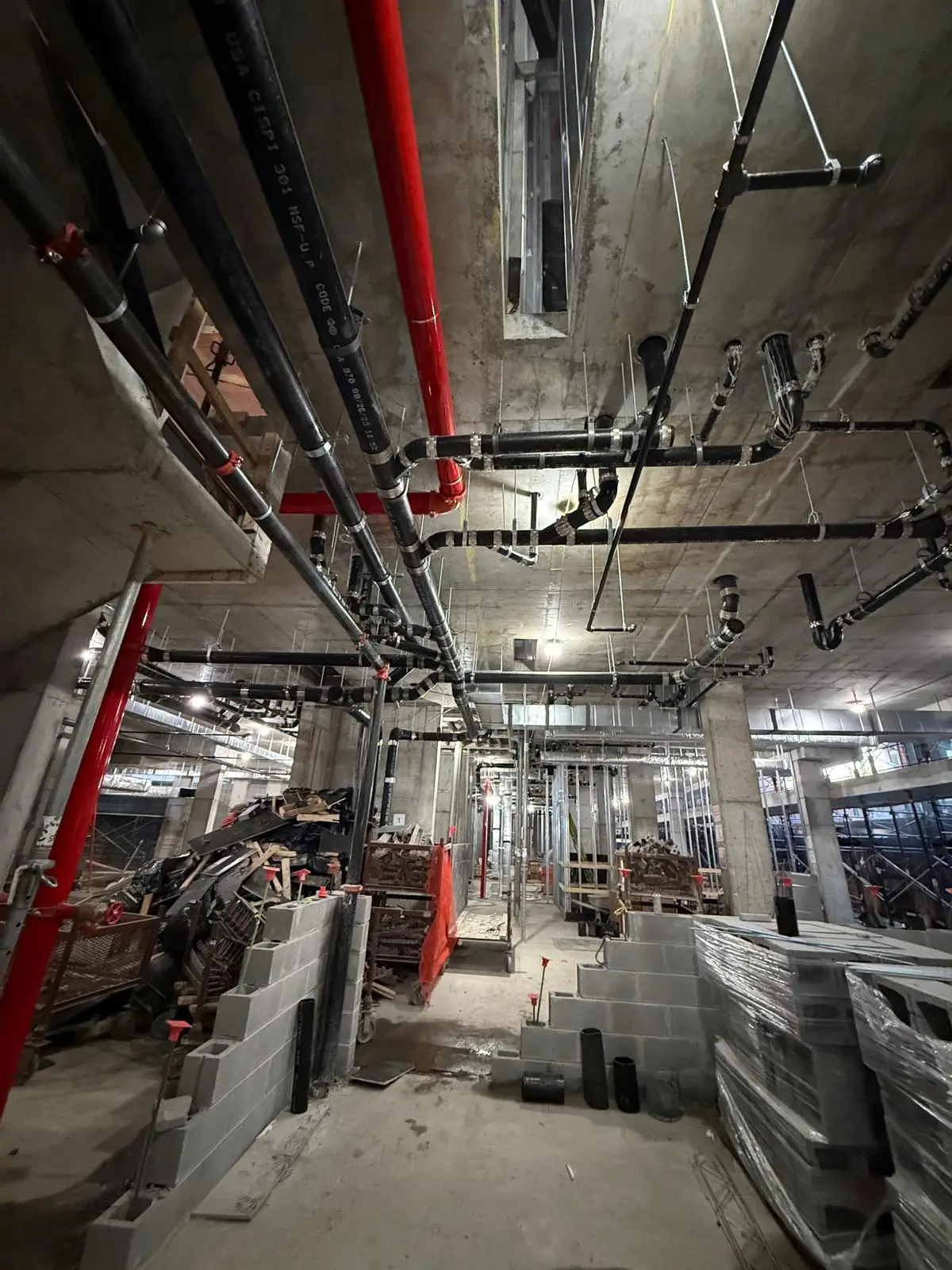 Commercial mechanical room with installed plumbing and sprinkler pipes