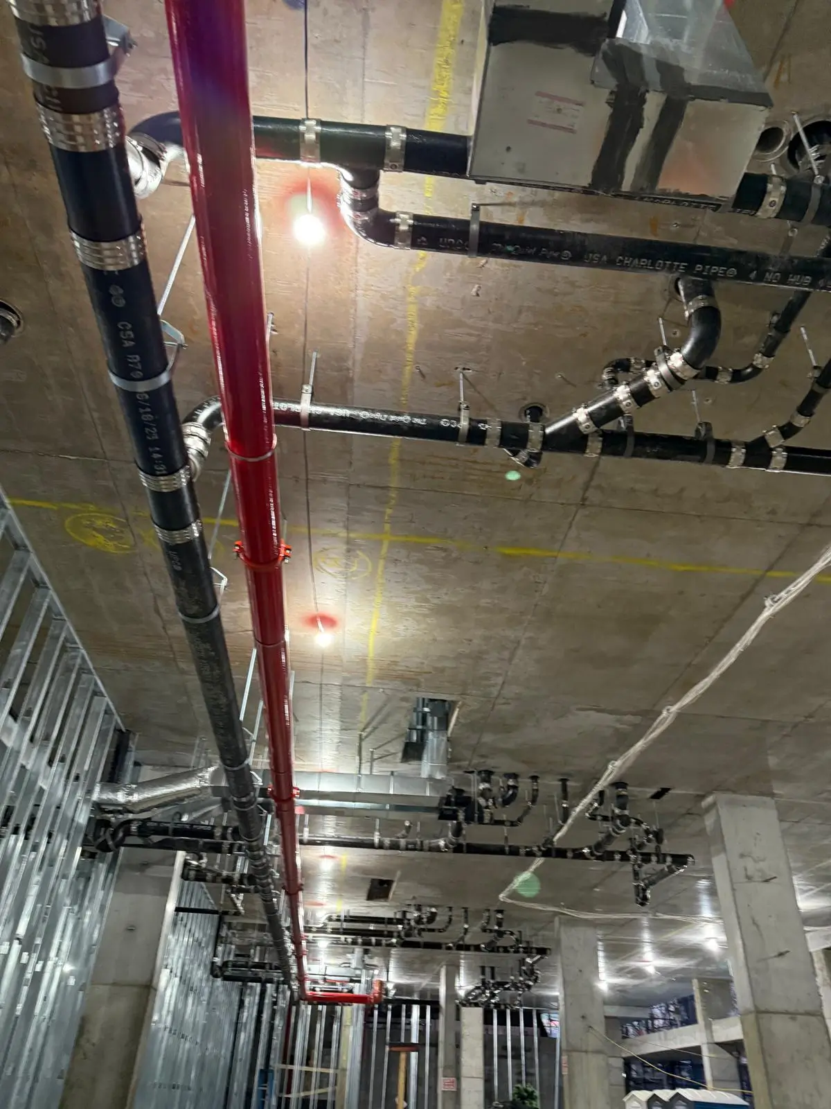Ceiling plumbing and piping installation at a commercial construction site